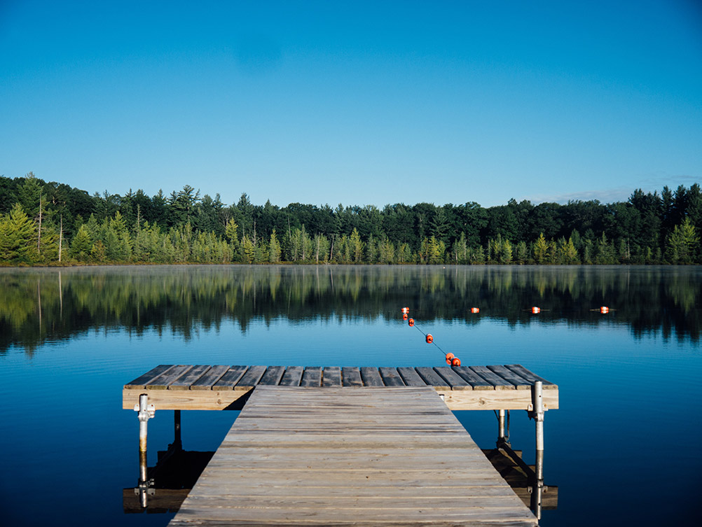 A dock stretching into the blue water of one of the many lakes located on the Boundary Waters.